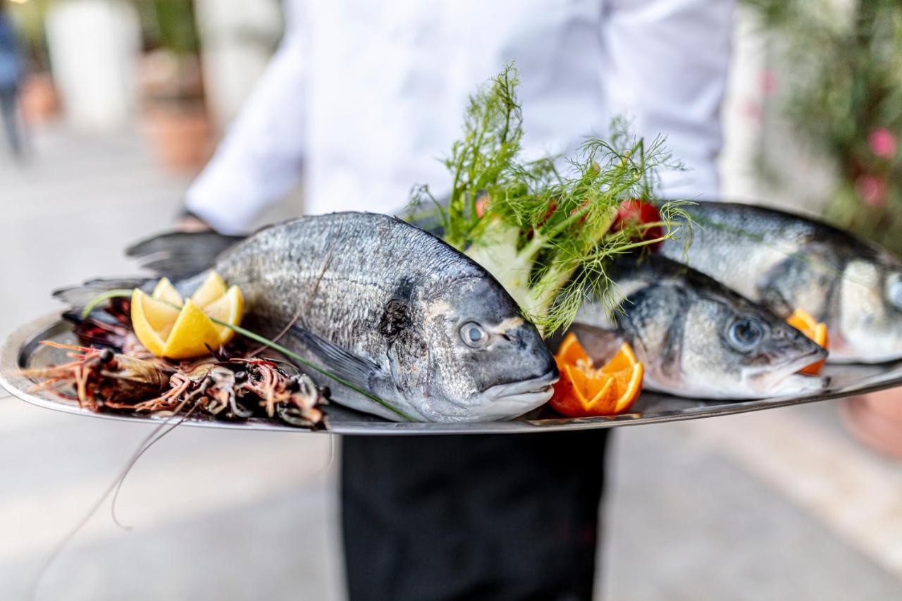 Lighthouse Golf & Spa Hotel Balchik Bagian luar foto A waiter holding a platter of fish